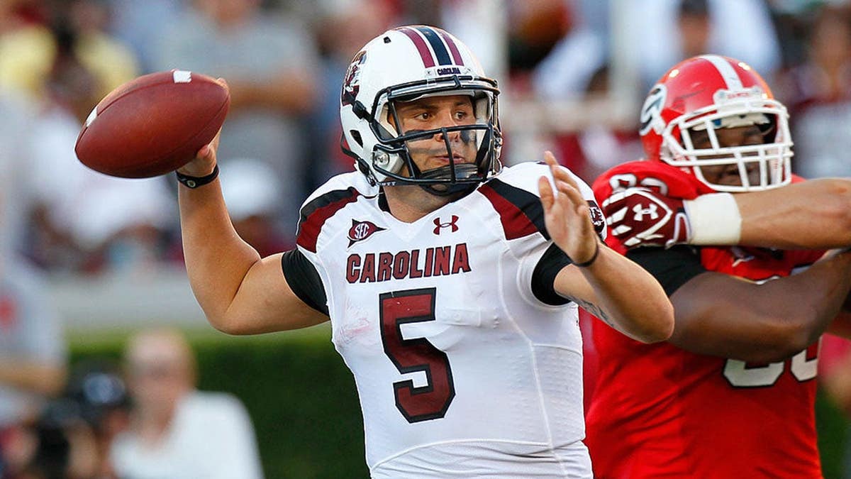 Stephen Garcia passing football during game at Sanford Stadium
