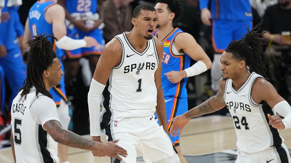 Stephon Castle, Victor Wembanyama y Devin Vassell reaccionan durante un NBA en San Antonio