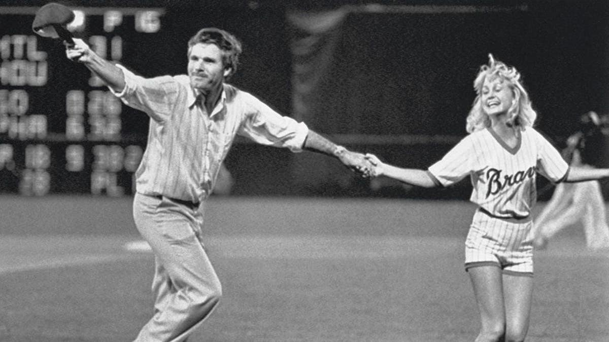 Ted Turner dancing with a team ball girl at a baseball game