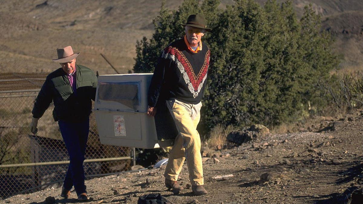 Ted Turner helping a biologist release two wolves on ranch property