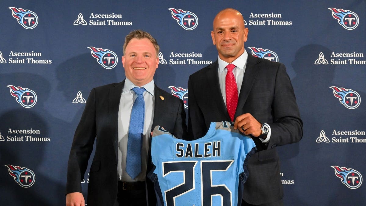 Tennessee Titans general manager Mike Borgonzi and head coach Robert Saleh hold a Titans jersey at a press conference