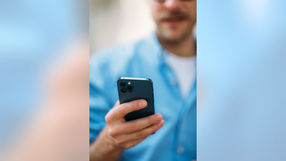 A person holds an IPhone.