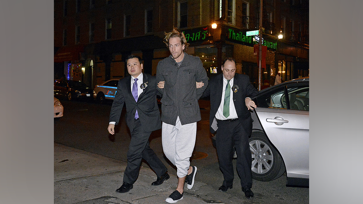 Thomas Gilbert Jr. is escorted by law enforcement officers after his arrest in New York City