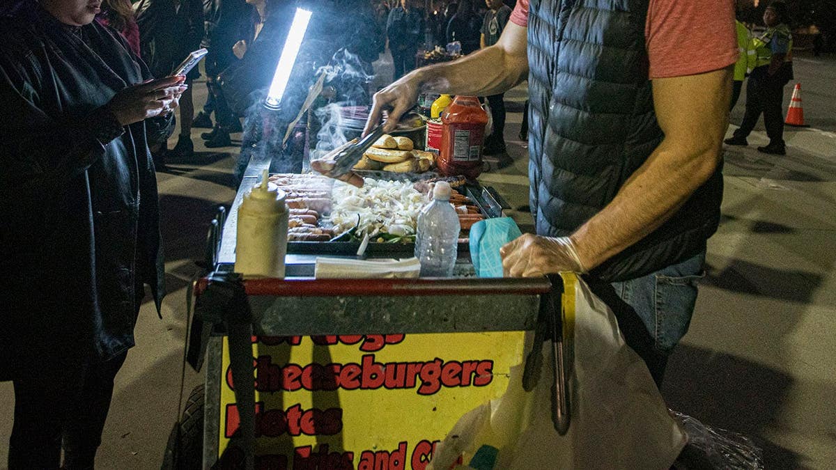 Street vendors selling Tijuana style hot dogs to concert goers in San Diego