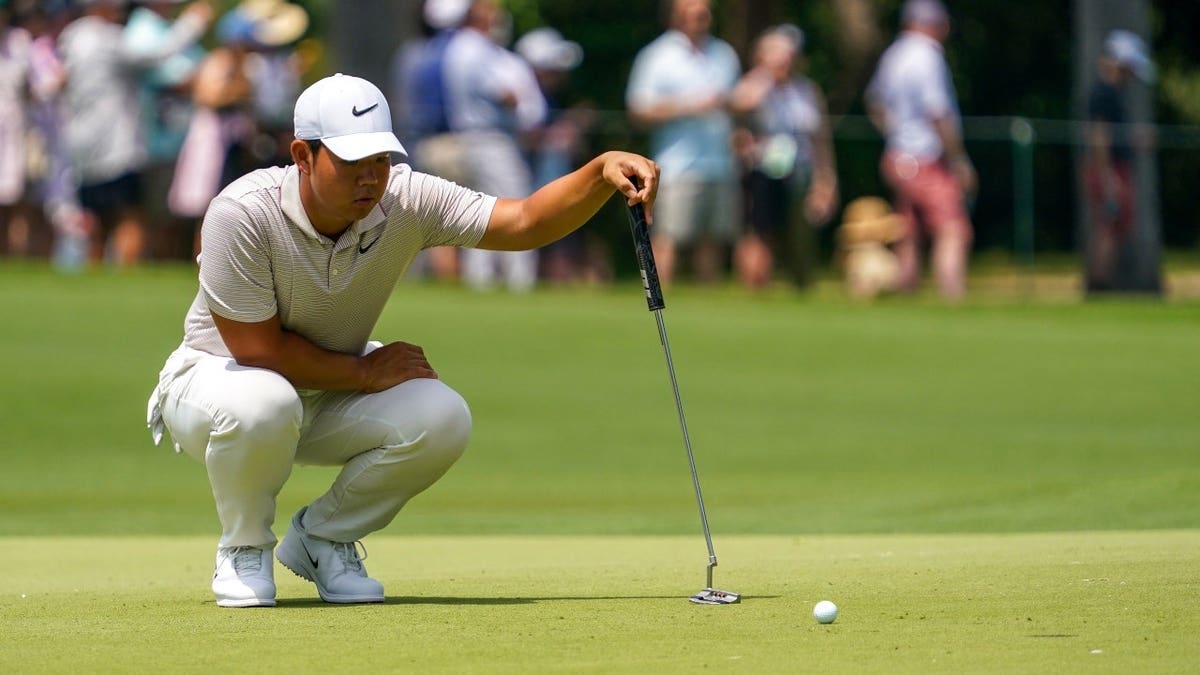 Tom Kim lines up a putt on the eighth green during the first round of the 2025 Charles Schwab Challenge at Colonial Country Club in Fort Worth, Texas.