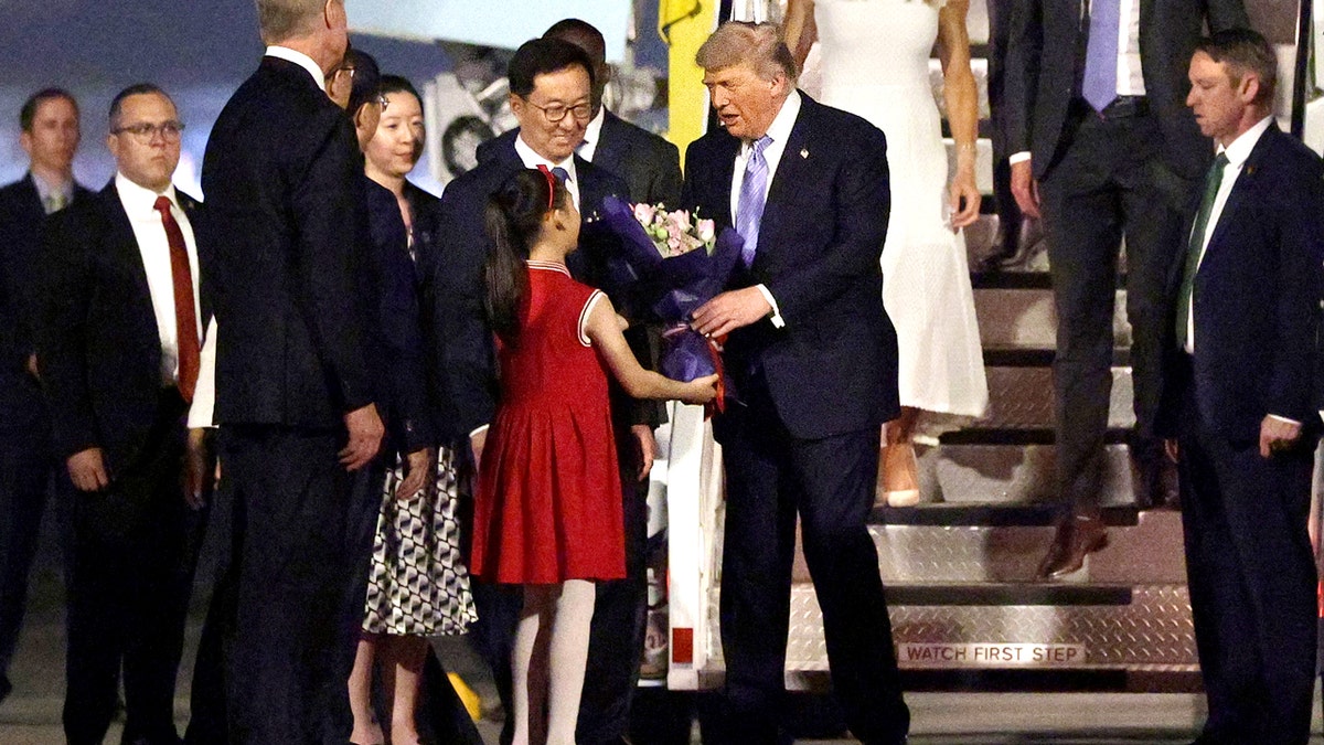 Trump recebe um buquê de flores de uma jovem na China