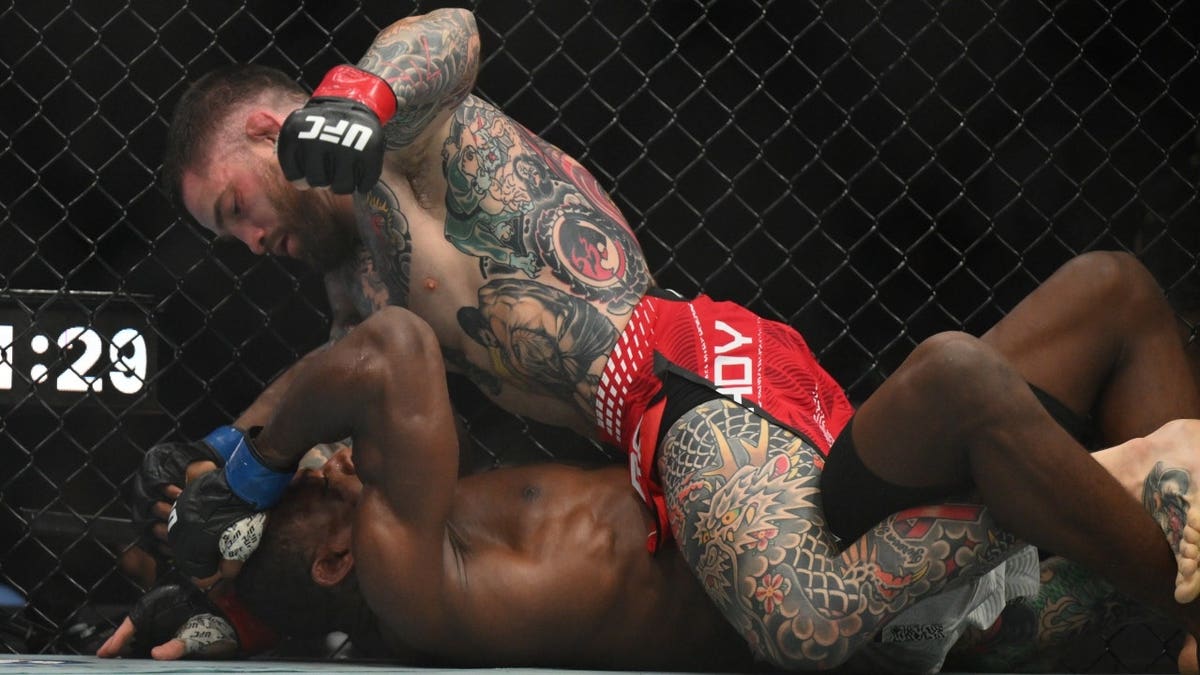 Sean Brady usando luvas vermelhas lutando contra Joaquin Buckley usando luvas azuis em uma luta do UFC