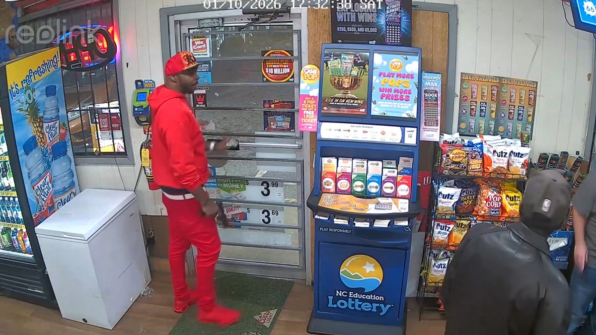 suspect is successful  reddish  garment  and pants seen holding what appears to beryllium  a weapon