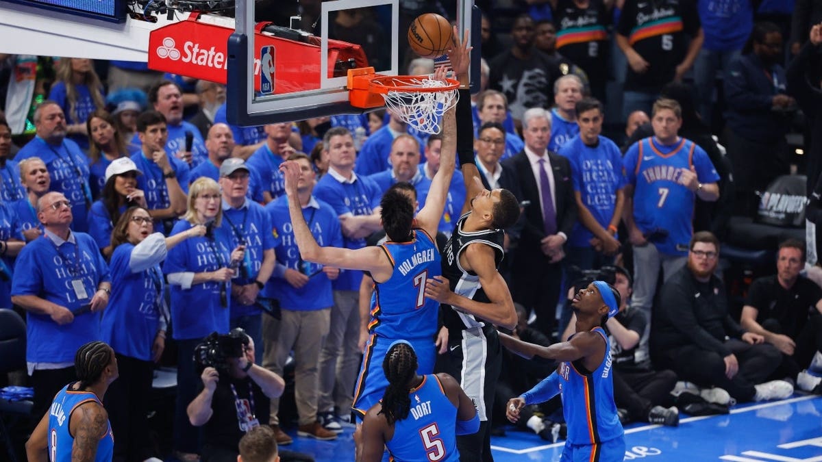 Victor Wembanyama shooting while defended by Chet Holmgren during basketball game
