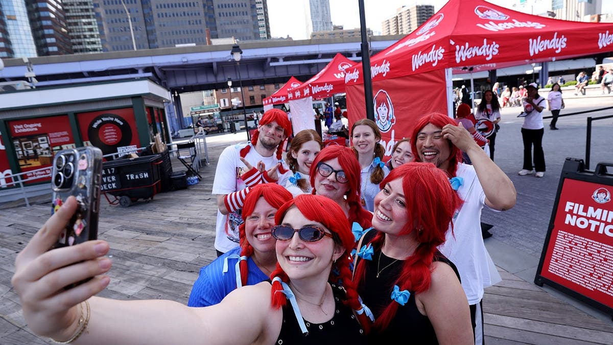 Several people in red wigs take a selfie together.