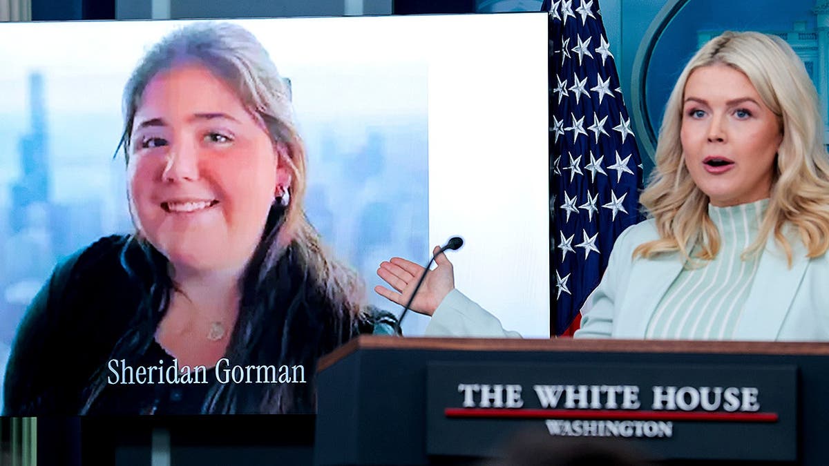 Karoline Leavitt speaks beside photo of slain college student during briefing.