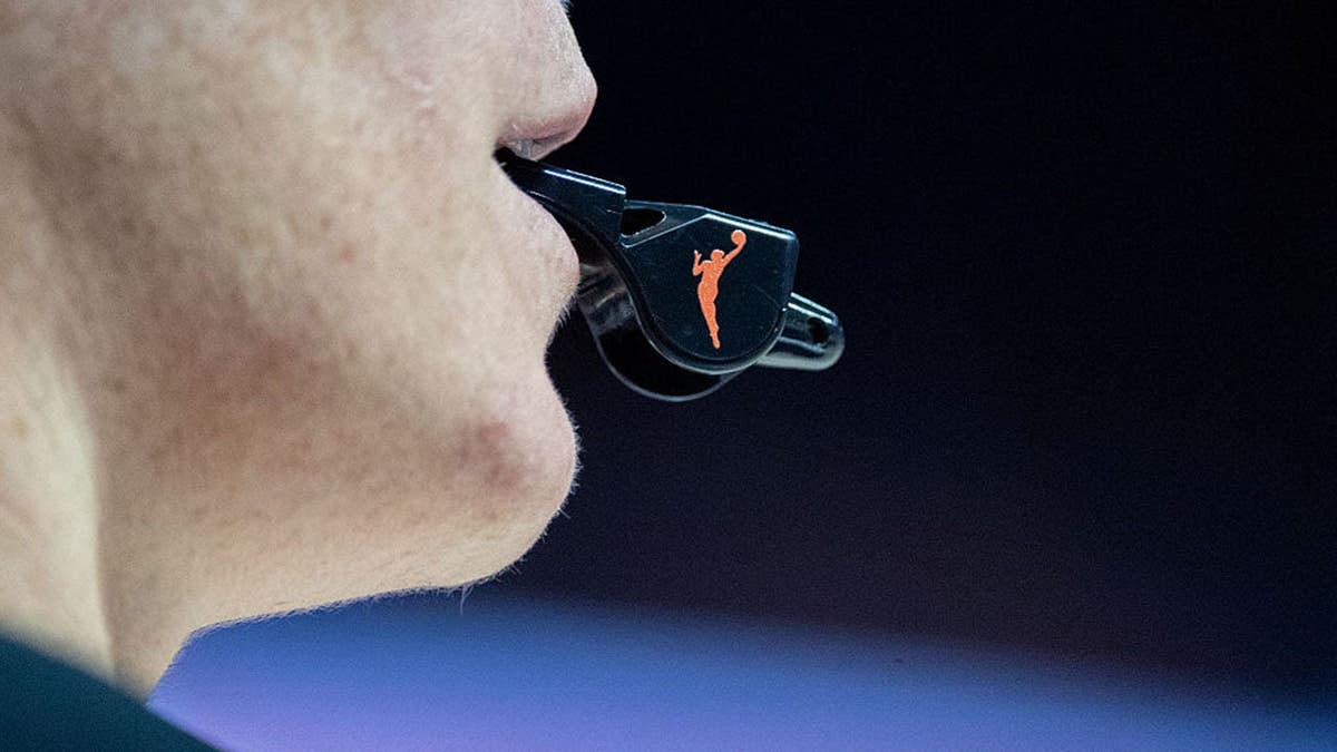 Close up of WNBA logo on a referee's whistle during a game.