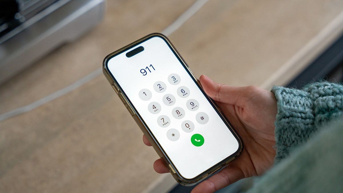 Woman dialing 911 on her smartphone in an emergency