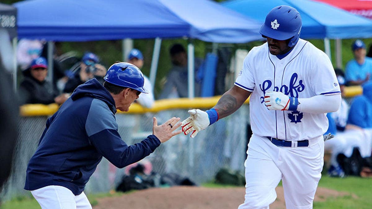 Yasiel Puig shakes hands with the third base coach after hitting a home run during a baseball game