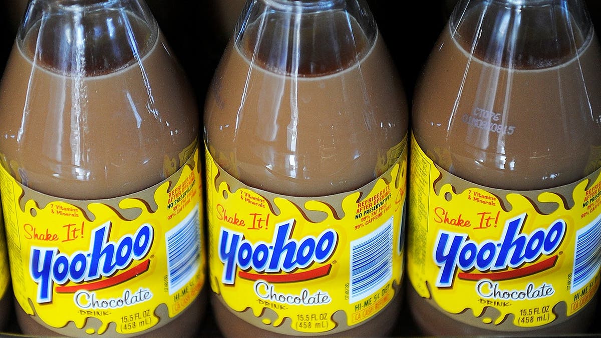 Three bottles of Yoo-hoo sit on a shelf.