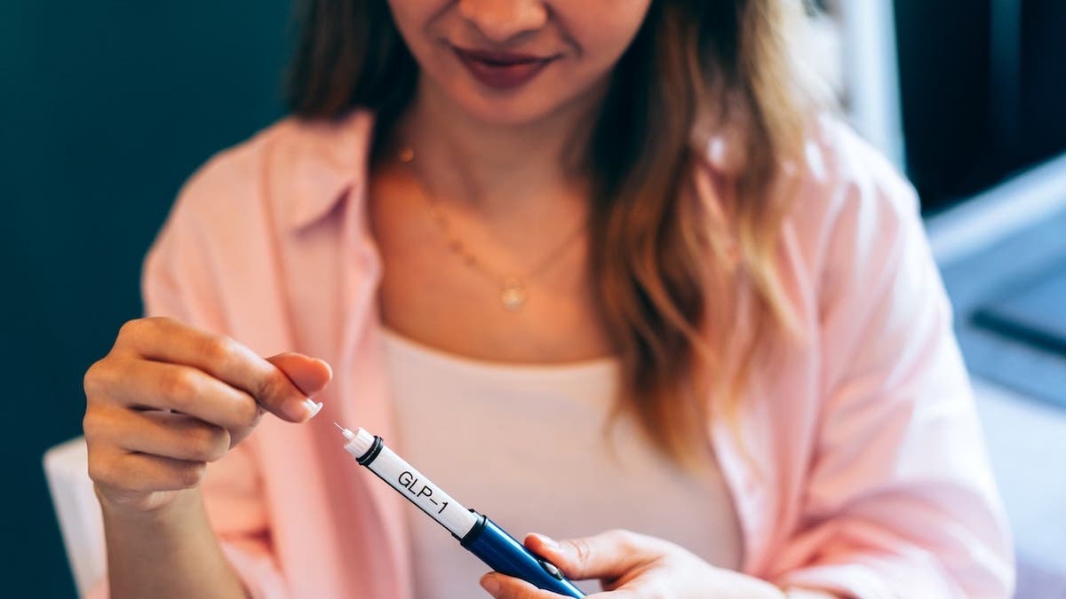 Young woman preparing GLP-1 injection pen at home