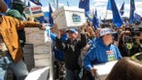 Supporters carrying boxes of signatures outside Elections Alberta building in Edmonton