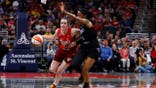 Indiana Fever guard Caitlin Clark dribbling basketball past Golden State Valkyries guard-forward Kaila Charles