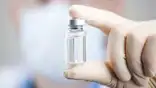 A doctor holding a vial and syringe preparing for injection