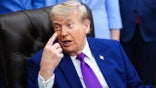 president donald trump points to his forehead