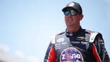 Kyle Busch standing in racing suit at Texas Motor Speedway