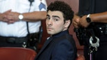 Luigi Mangione appearing at an evidence suppression hearing in a courtroom.
