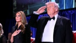 Donald Trump saluting with Melania Trump with hand over her heart at WHCA dinner