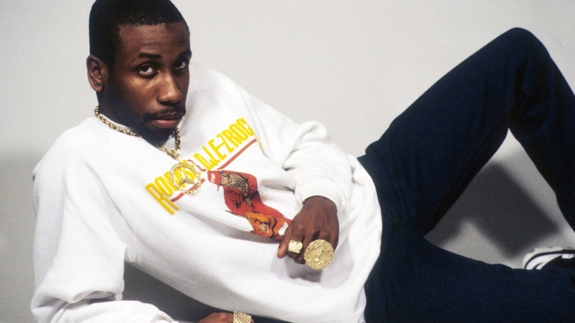 Rapper Rob Base posing for a portrait wearing a sweatshirt with his likeness