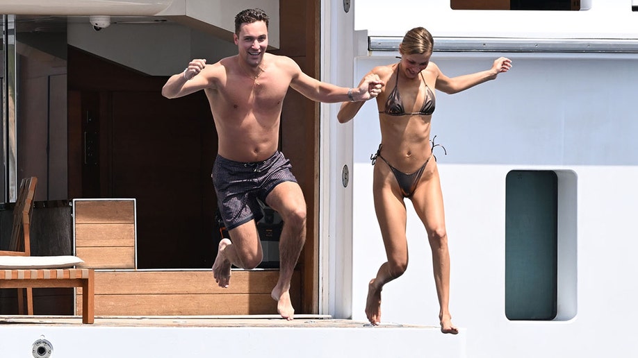 Bella Hadid and her friend jumping into the ocean.