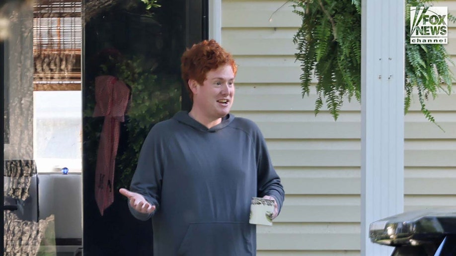 Buster Murdaugh sits on the front porch of a home while holding a coffee cup.