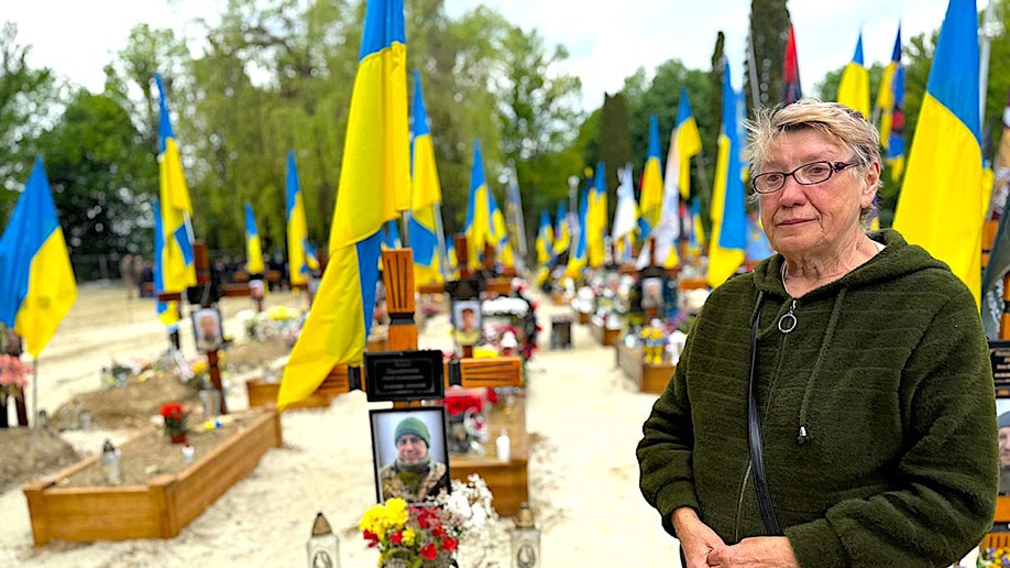 Woman mourns her nephew at Lviv cemetery.