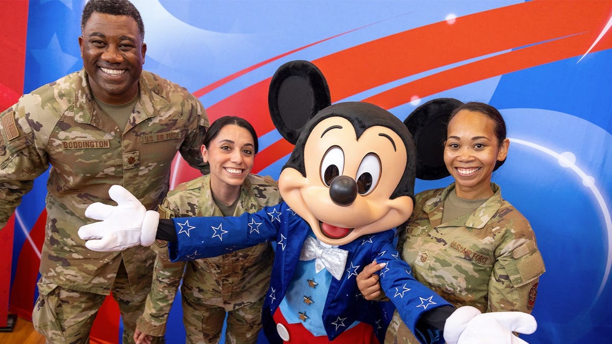 Mickey Mouse poses with American servicemembers