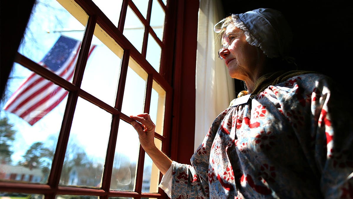 Woman looking out window at Buckman Tavern