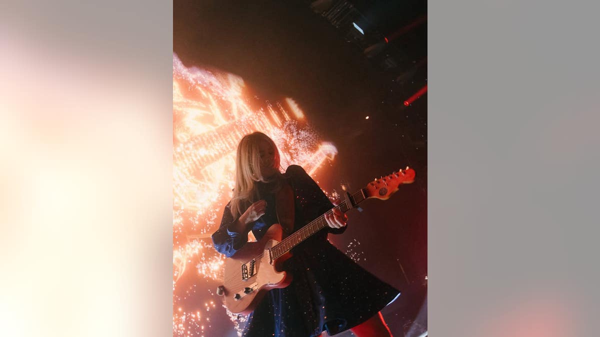Anne Wilson no palco tocando guitarra elétrica.