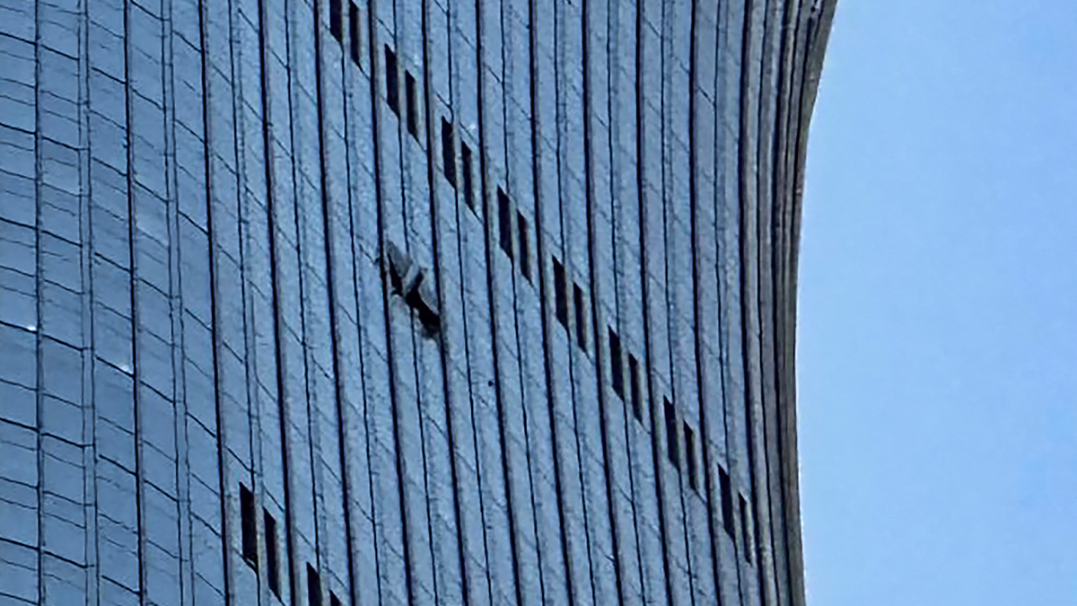A hole is seen (R) on the side of the CITIC Tower in Beijing on June 26, 2026, after a reported plane crash.