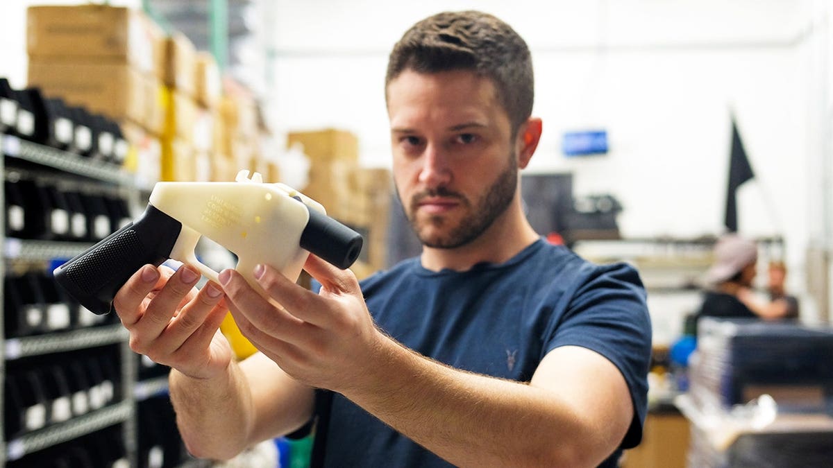 Cody Wilson, owner of Defense Distributed company, holds a 3D printed gun, called the