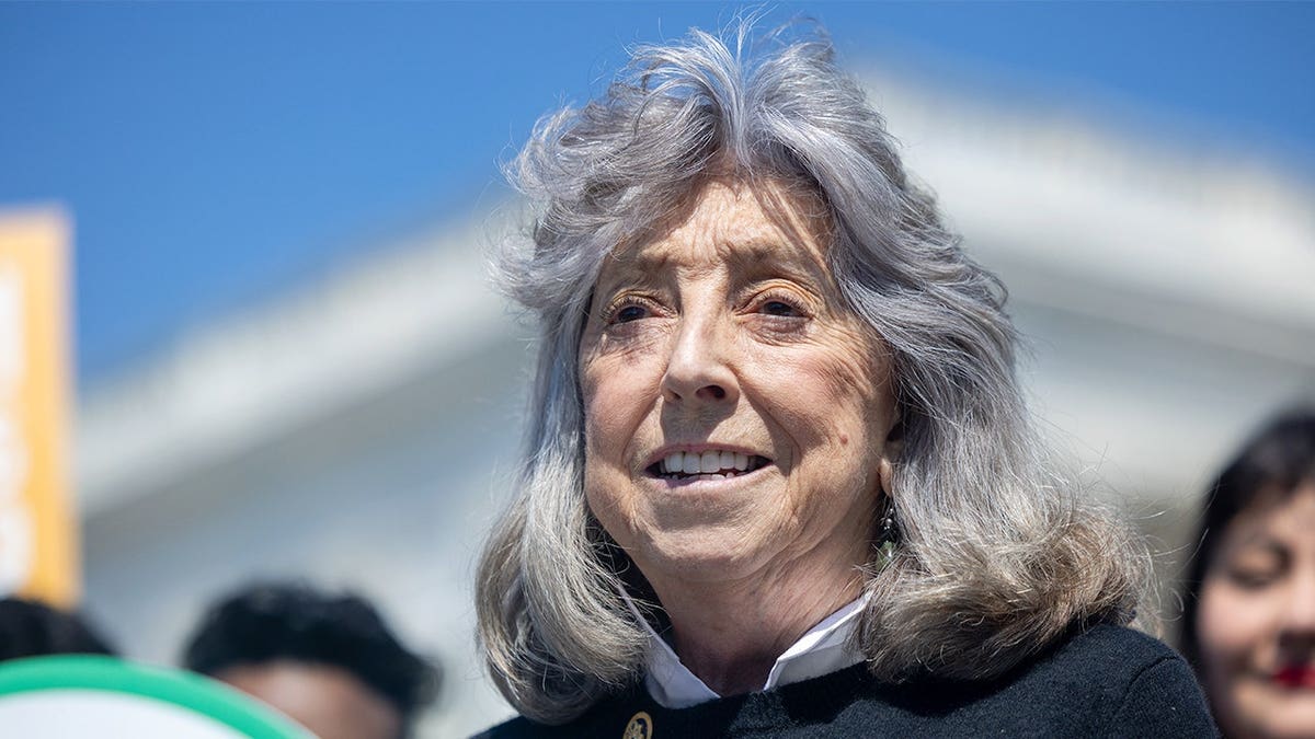 Dina Titus speaking at a podium during a press conference outside the U.S. Capitol.