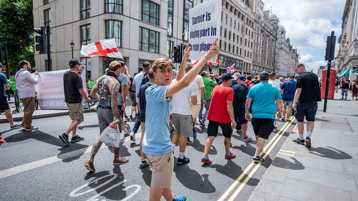 manifestante segura um cartaz acusando o primeiro-ministro Sir Keir Starmer de ignorar o escândalo da Grooming Gang durante um comício
