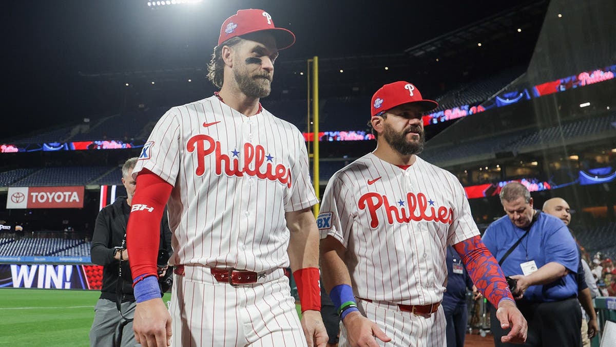 Bryce Harper e Kyle Schwarber saindo do campo após um jogo