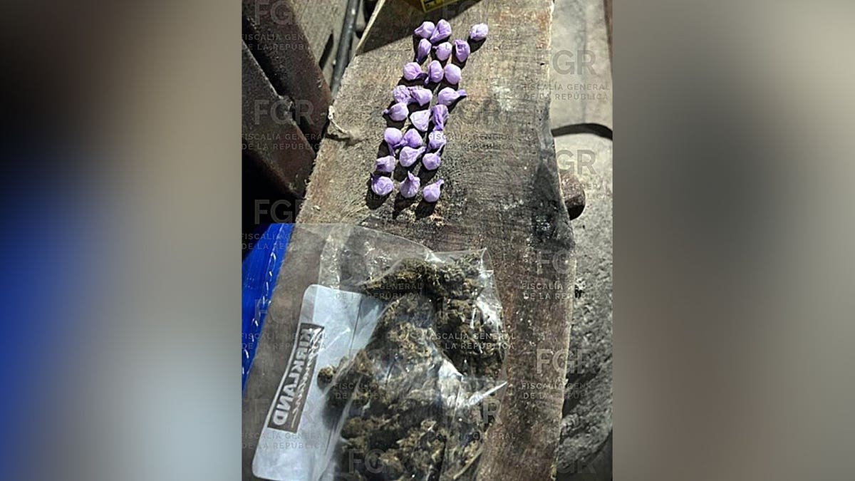 Unos paquetes pequeños envueltos en papel morado y una bolsa con lo que parece ser marihuana, todo ello sobre una mesa.