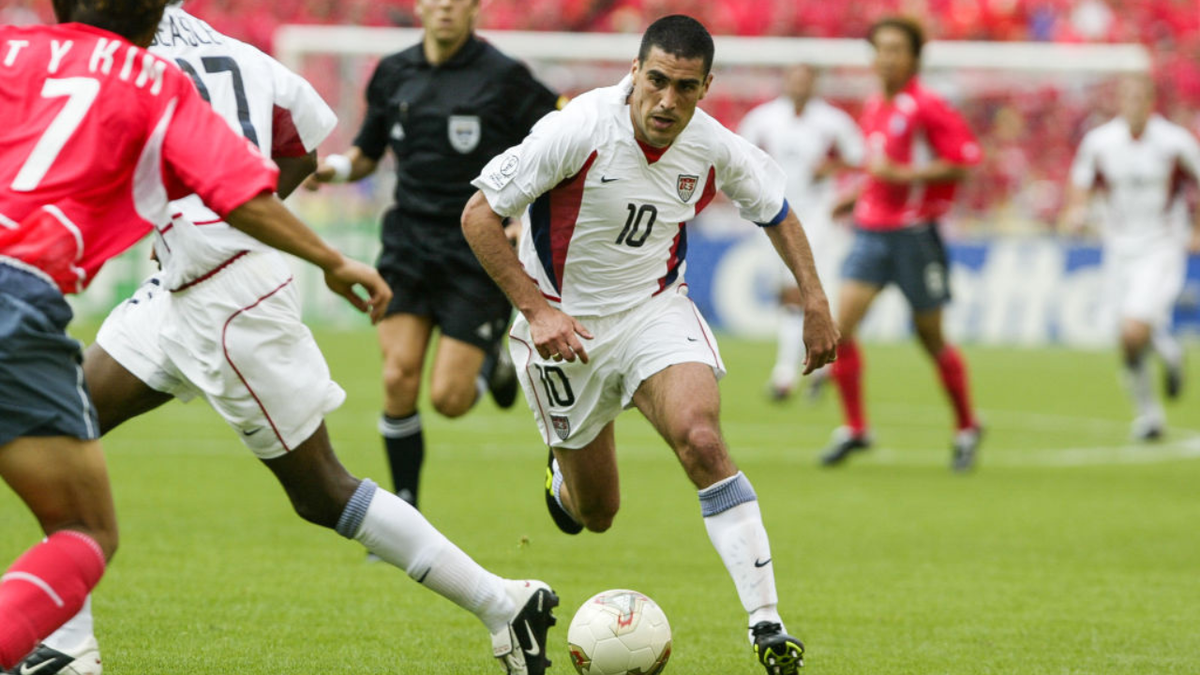 Claudia Reyna of the USA running with the soccer ball on the field.