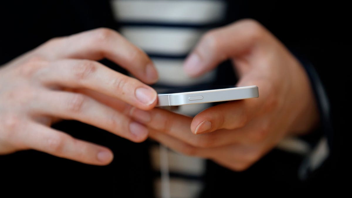 Woman typing on her iPhone.