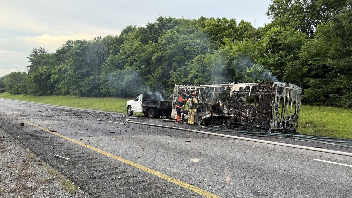 Firefighters inspect a burned trailer that was carrying fireworks after a fire on Interstate 75 near Ooltewah, Tennessee.