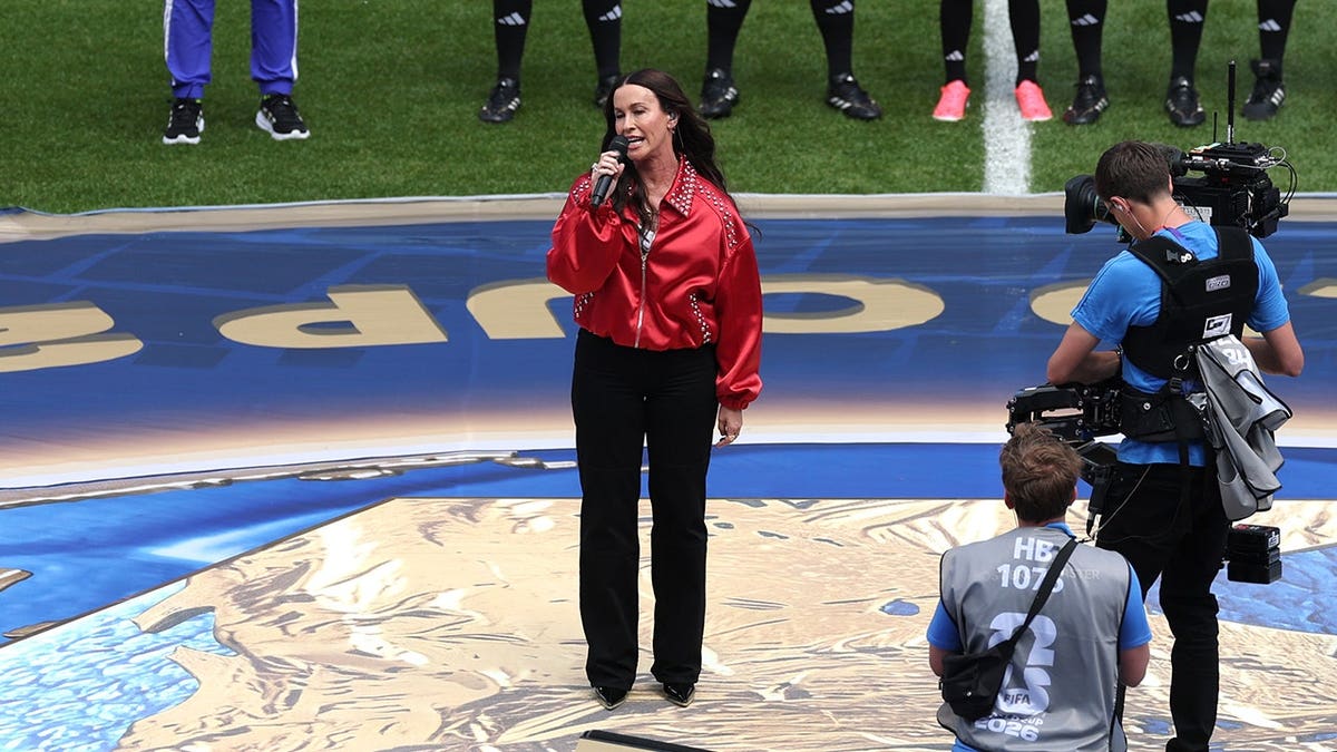 Alanis Morissette com jaqueta vermelha e calça preta no jogo da Copa do Mundo de 2026, em junho de 2026, entre Canadá e Bósnia e Herzegovina.