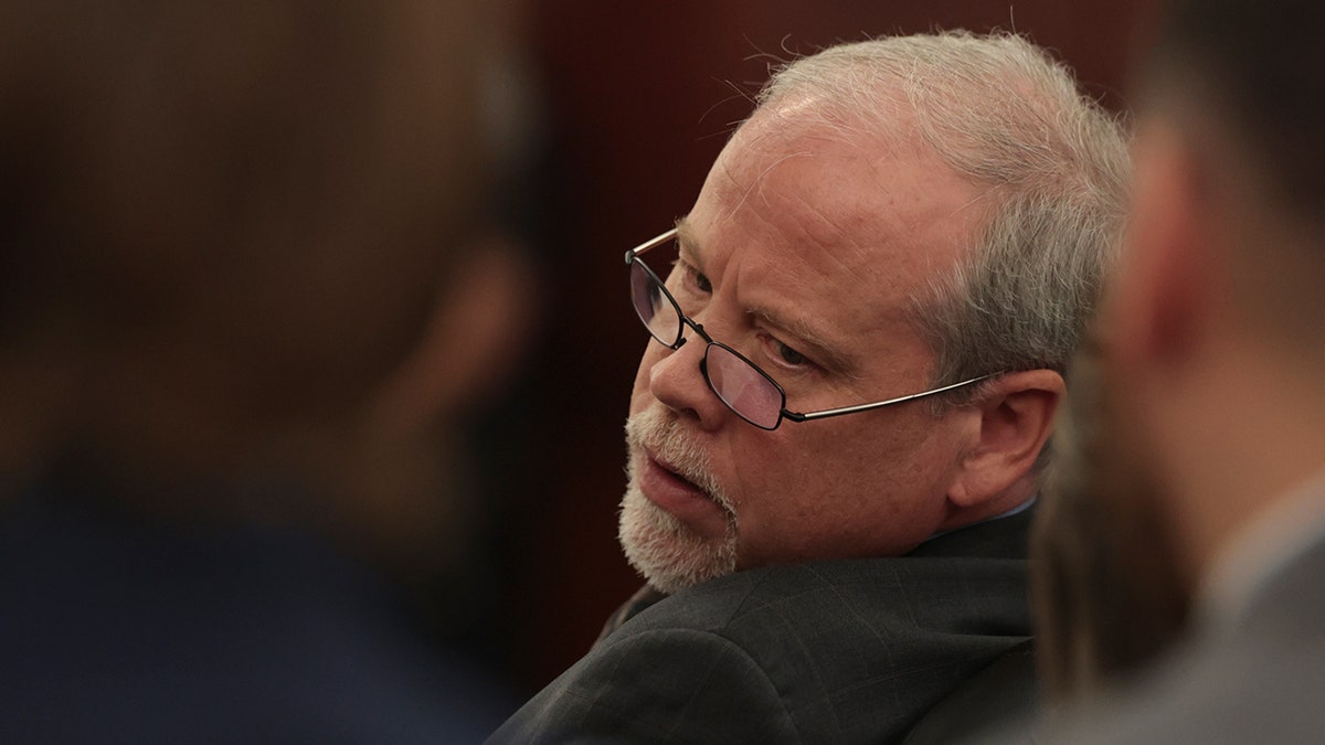 Prosecutor wearing glasses in court.