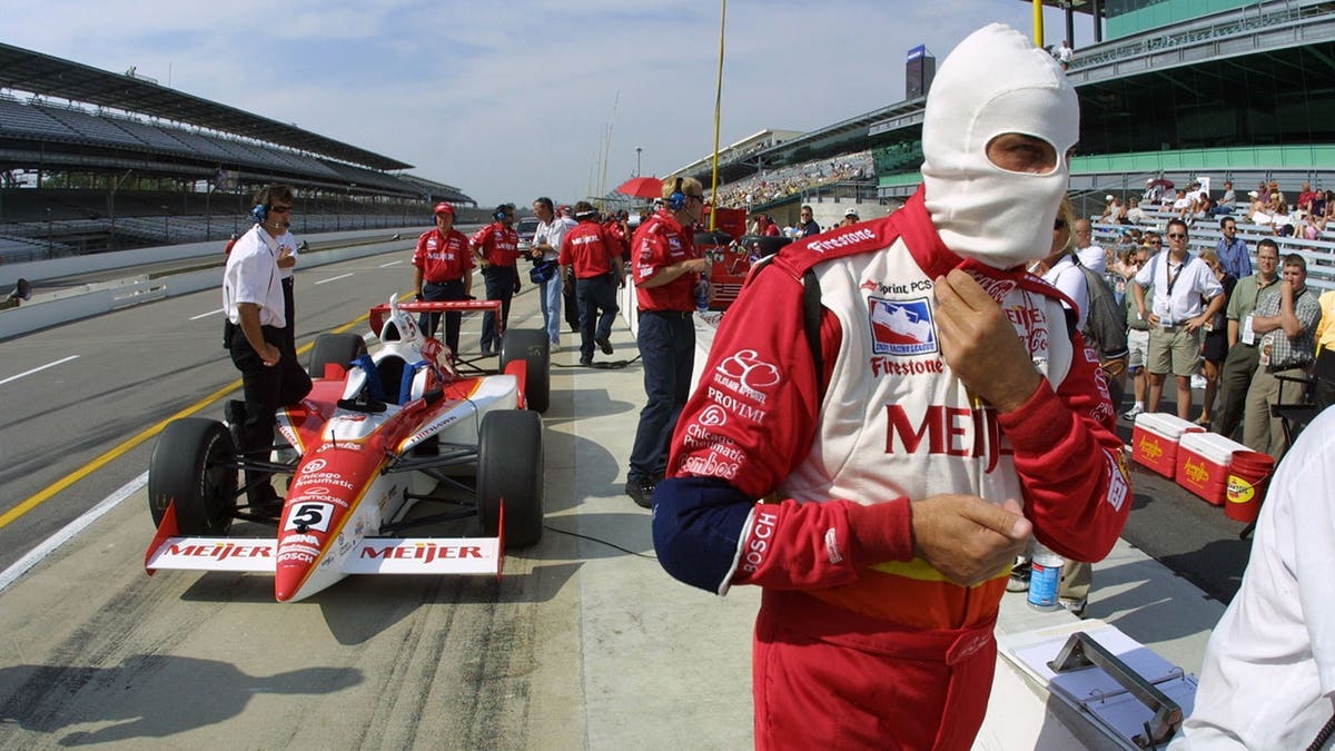 Arie Luyendyk putting on fire retardant mask before entering race car at Indianapolis Motor Speedway