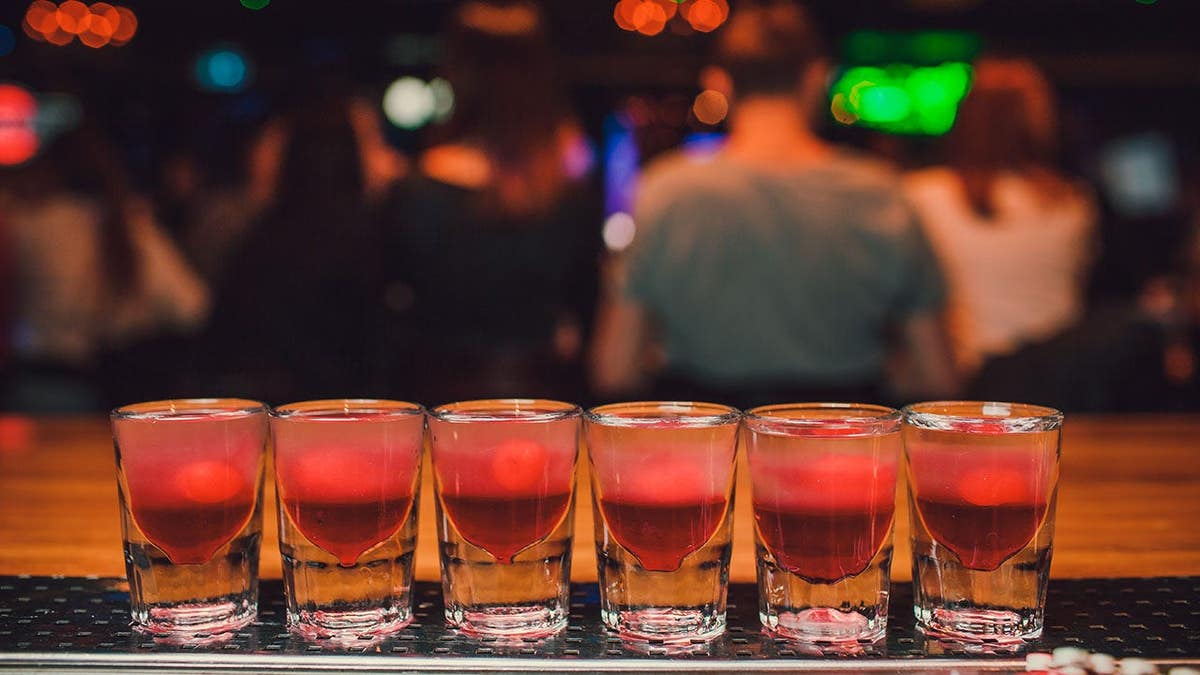 Bartender pouring tequila into a glass at a bar