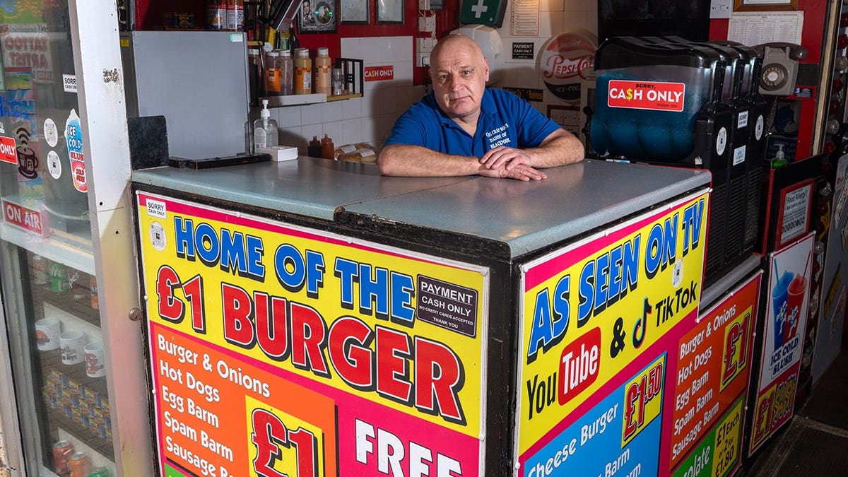 Christopher Higgitt standing outside his £1 burger stand in Blackpool