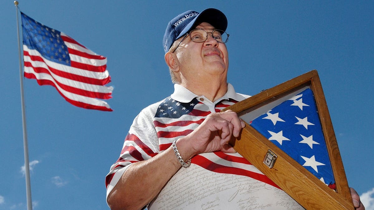 Bob Heft holding the original 50-star American flag design in front of Draper Chevrolet