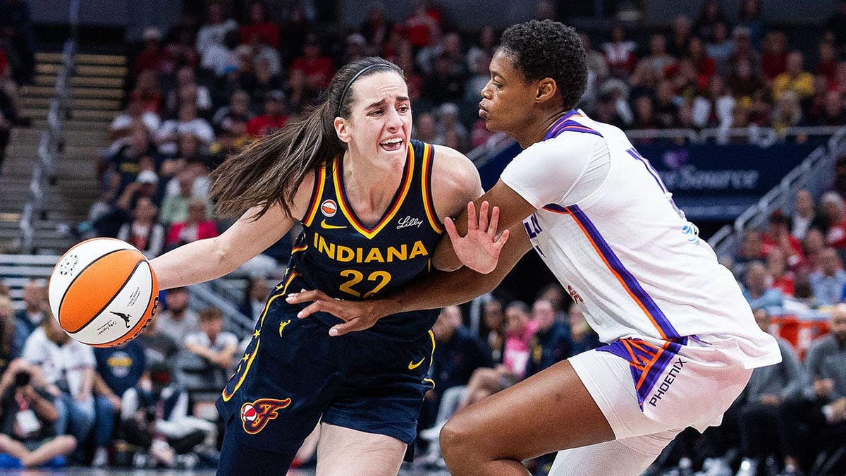 A armadora do Indiana Fever, Caitlin Clark, driblando no basquete defendida pela atacante do Phoenix Mercury, Valeriane Ayayi, no Gainbridge Fieldhouse